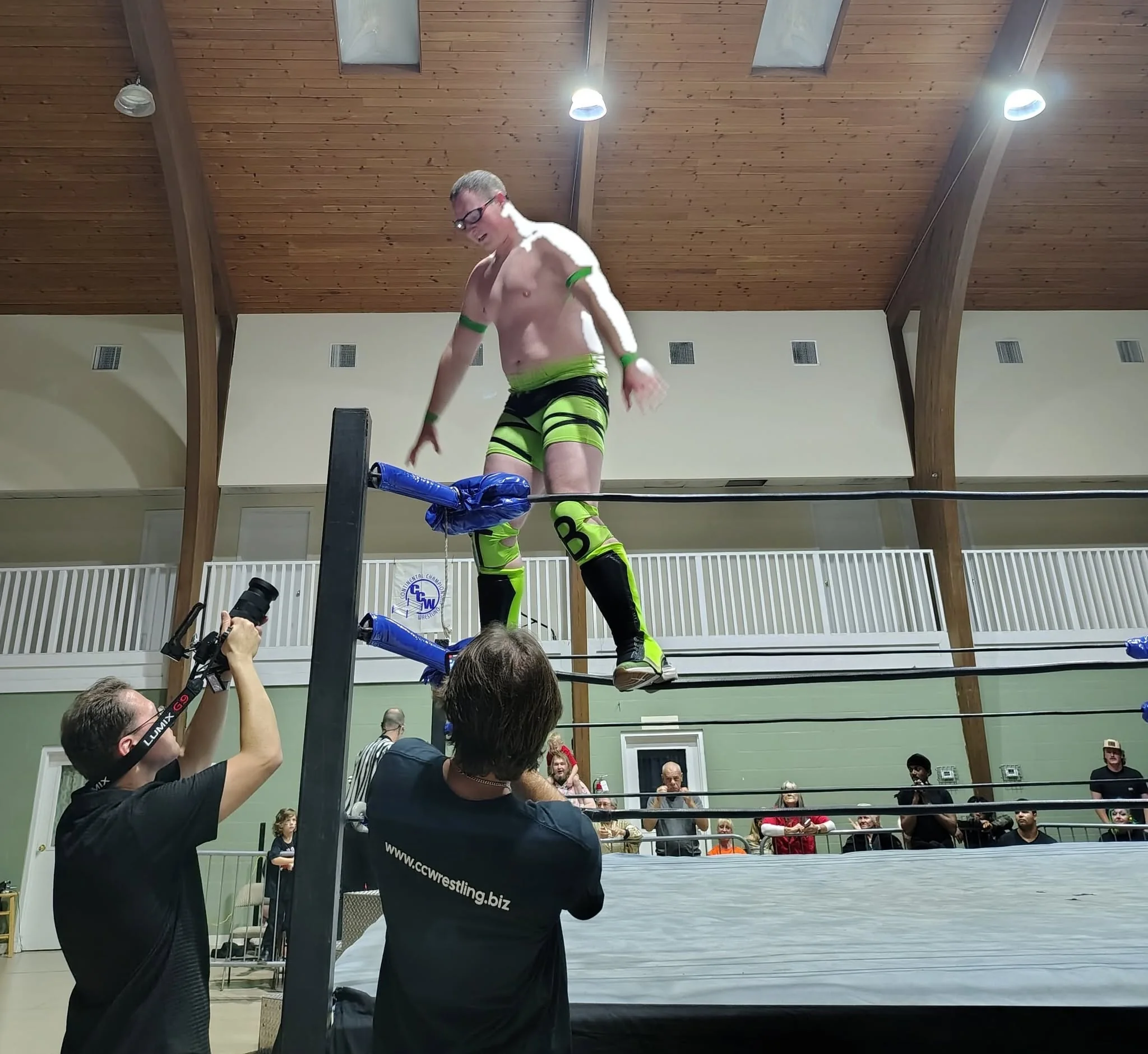 Camera operator filming a wrestler on the ropes